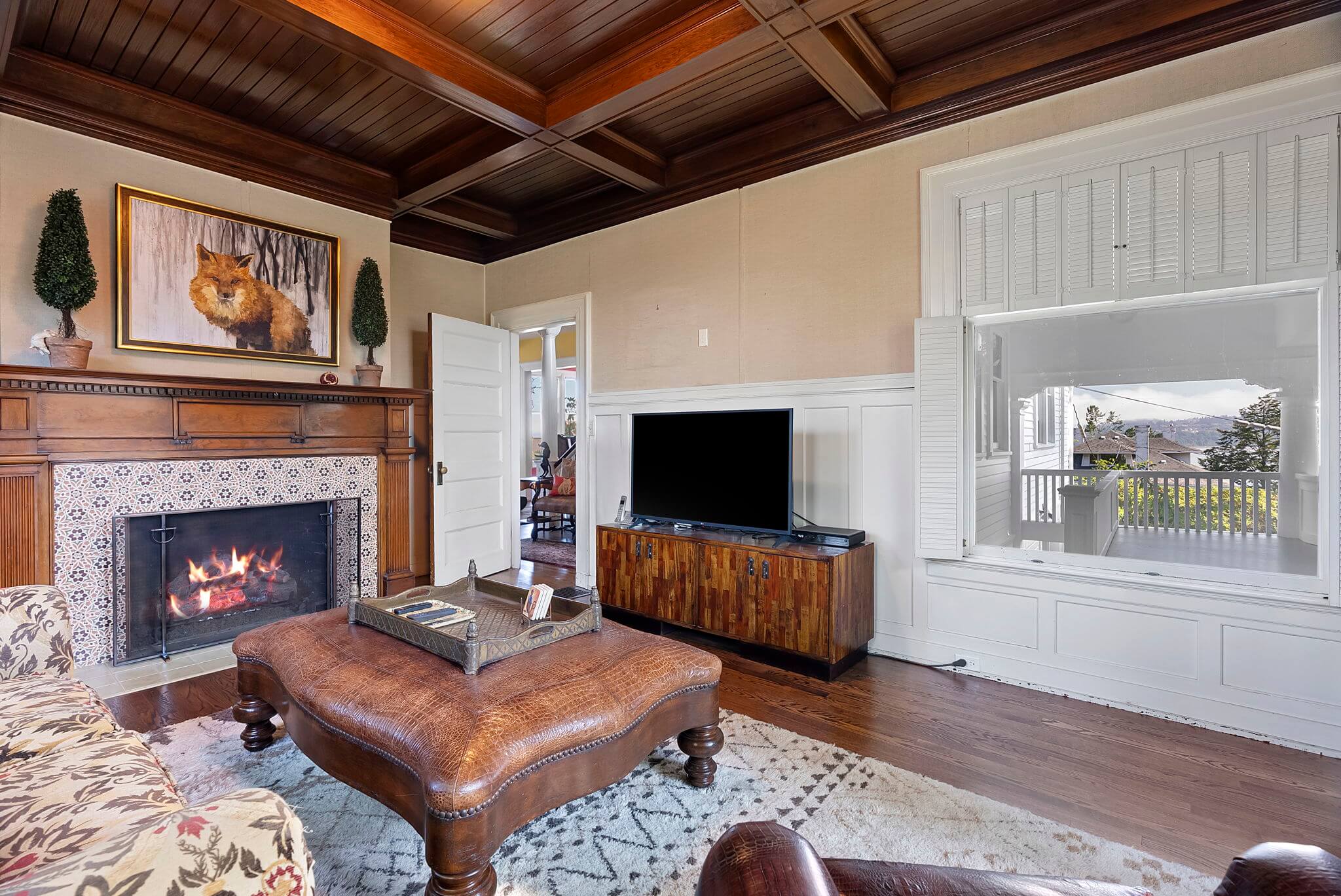 Library features a large fireplace with original mantle and vintage tile surround
