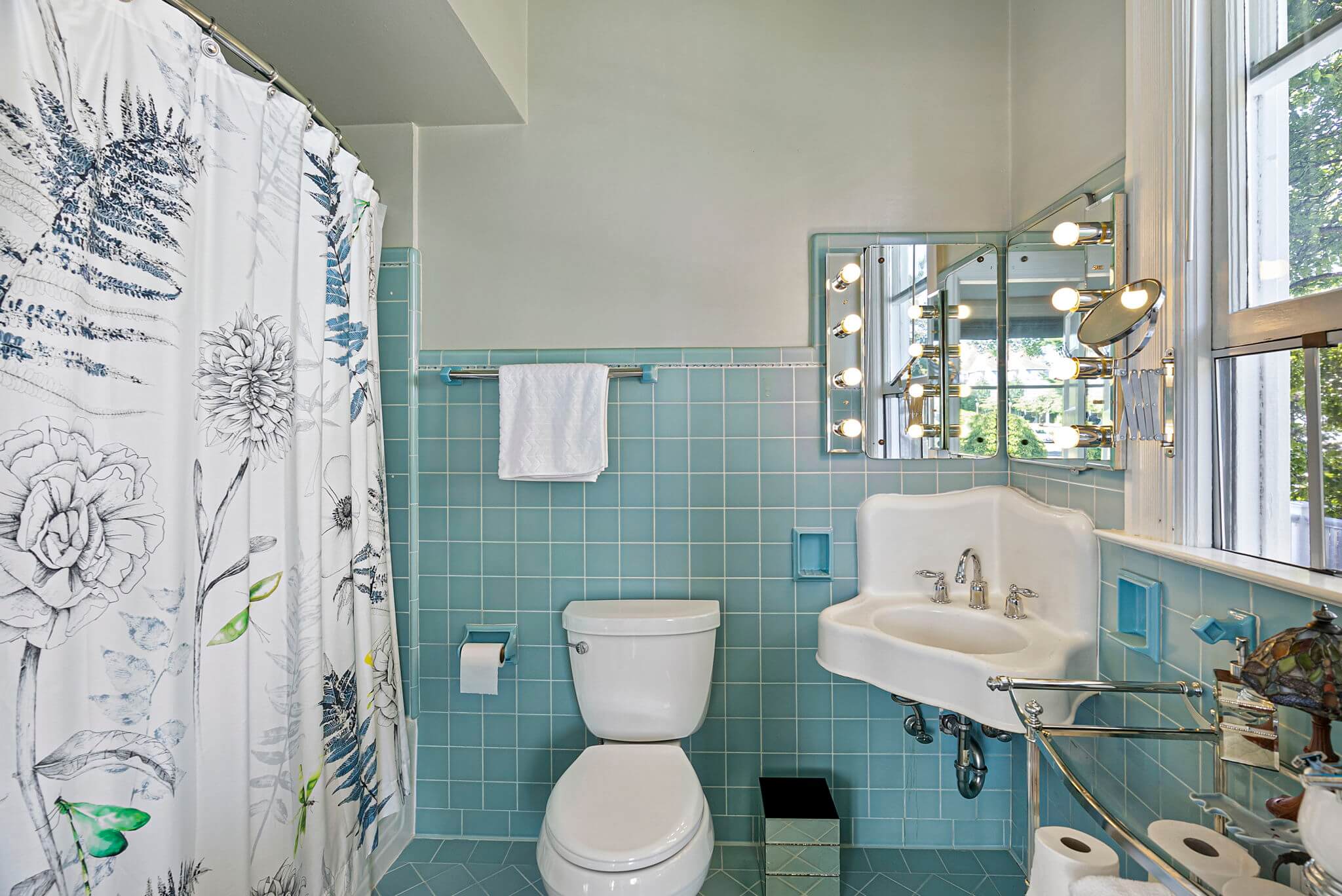 En suite primary bathroom with vintage tile and corner sink