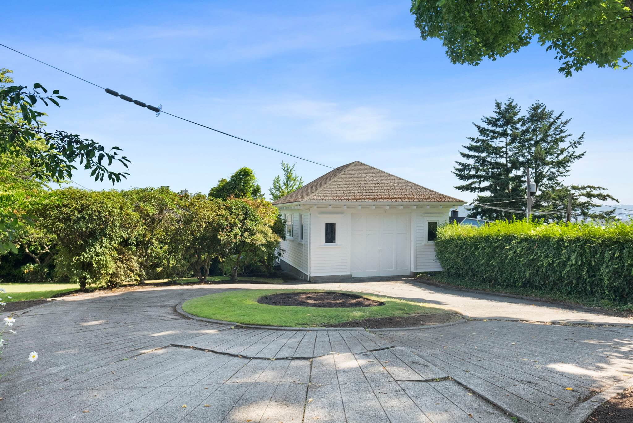 Circular driveway beyond the porte-cochere leads to a detached garage