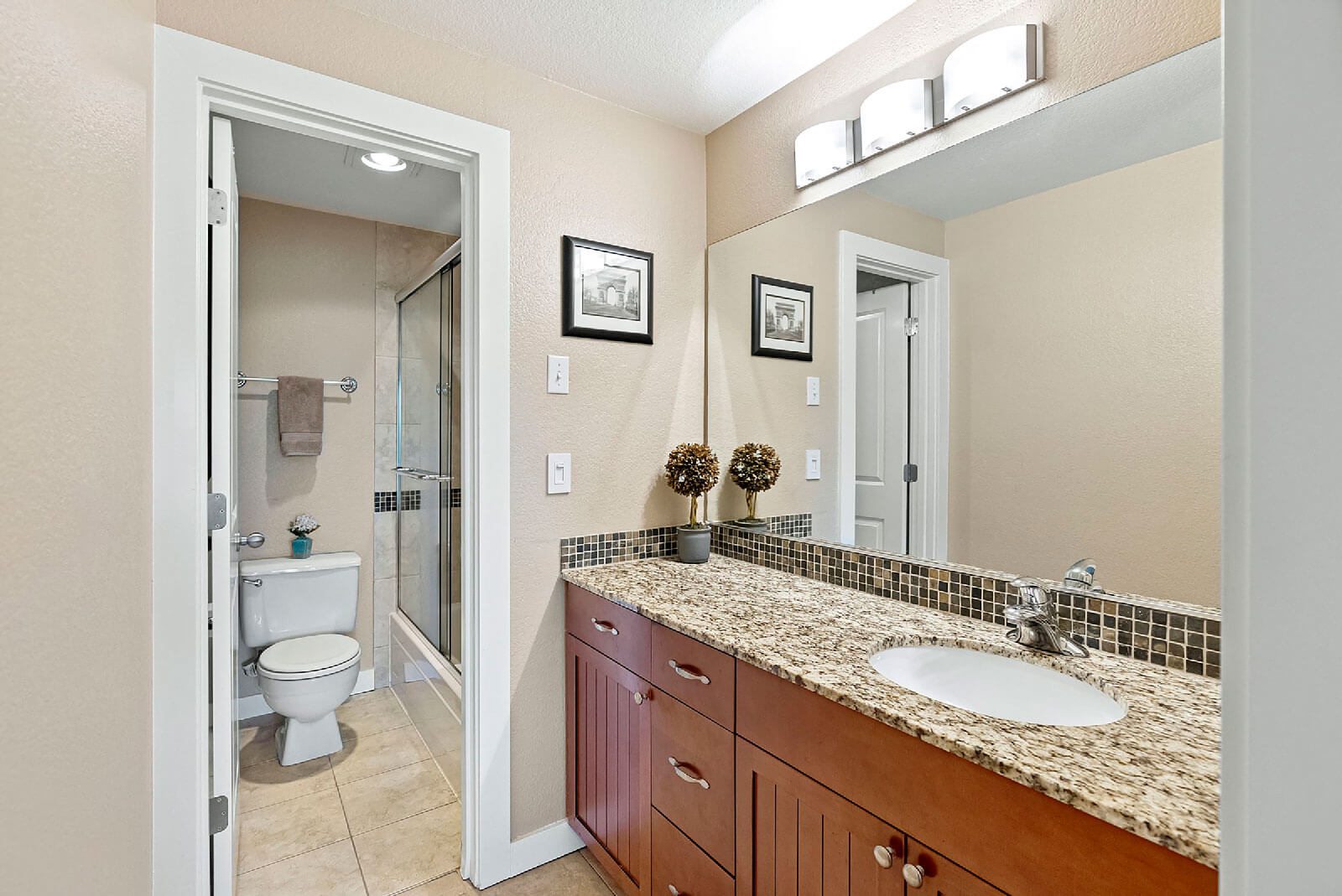 En suite bathroom with granite topped vanity and tub/shower