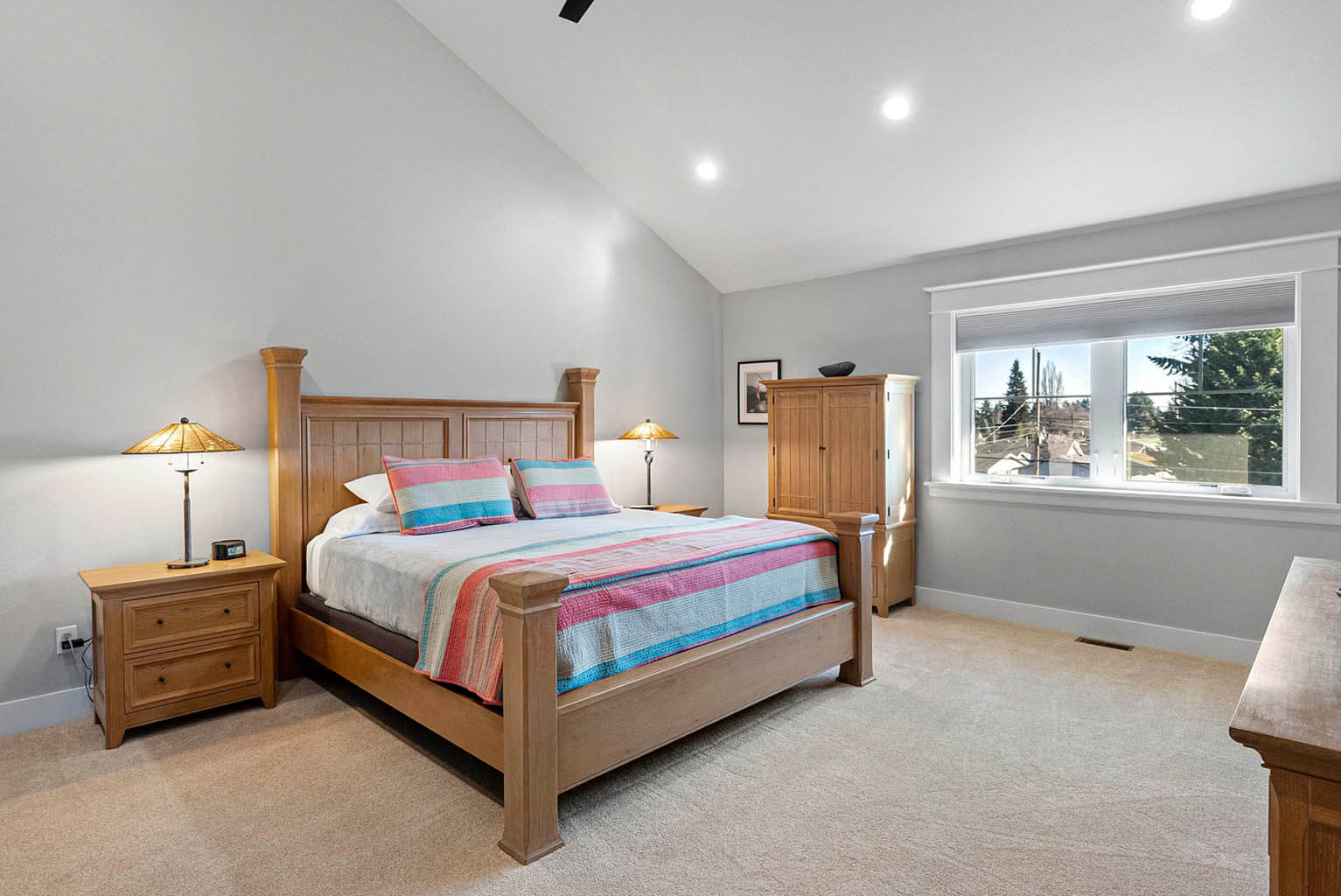 Spacious primary bedroom with vaulted ceiling