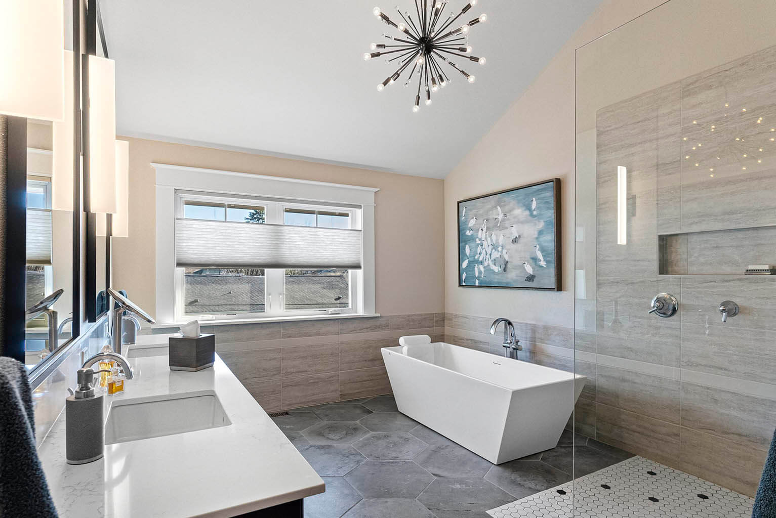 Updated primary bathroom with dual sink vanity and deep soaking tub