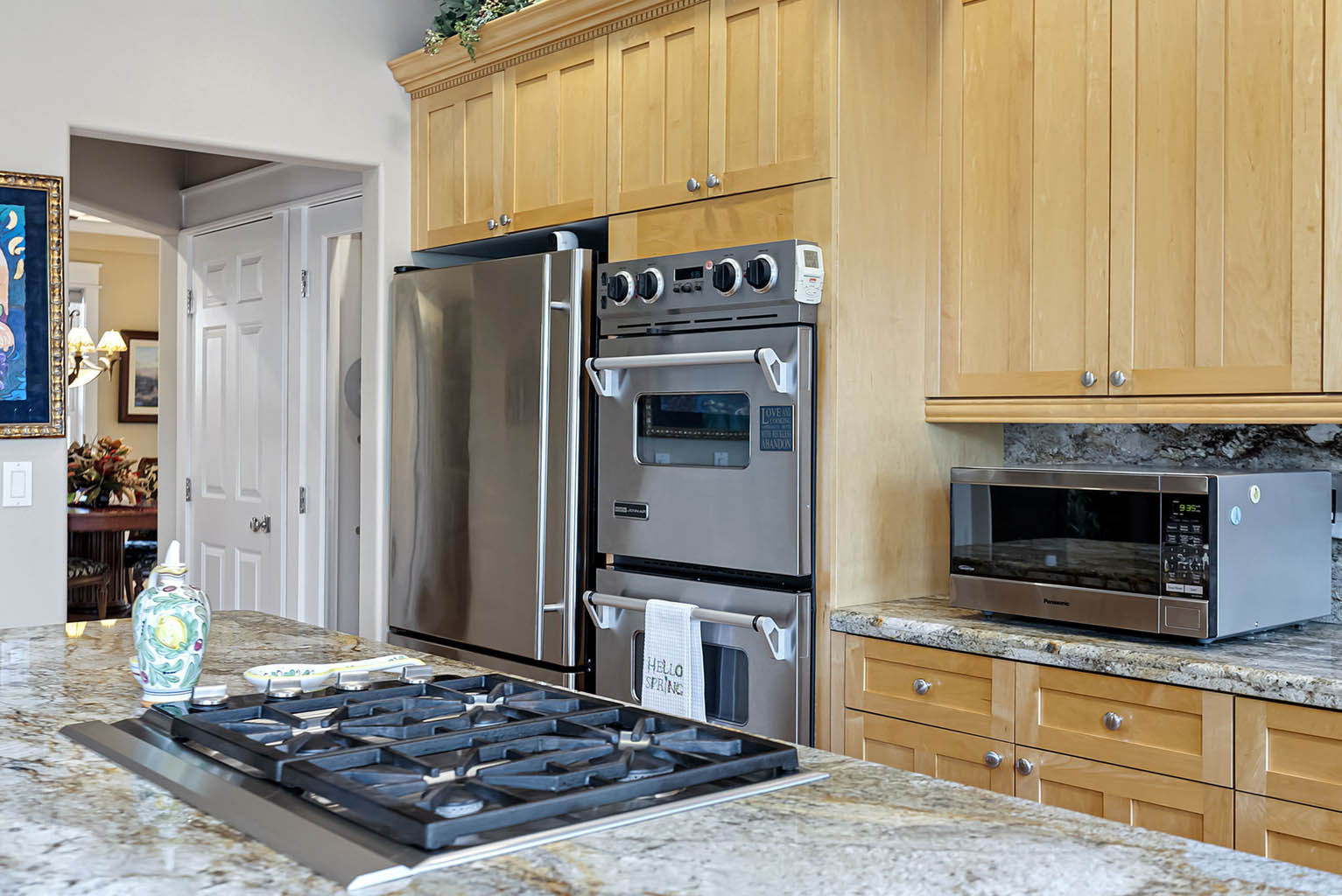 Stainless appliances including JennAir double ovens and Wolf downdraft cooktop