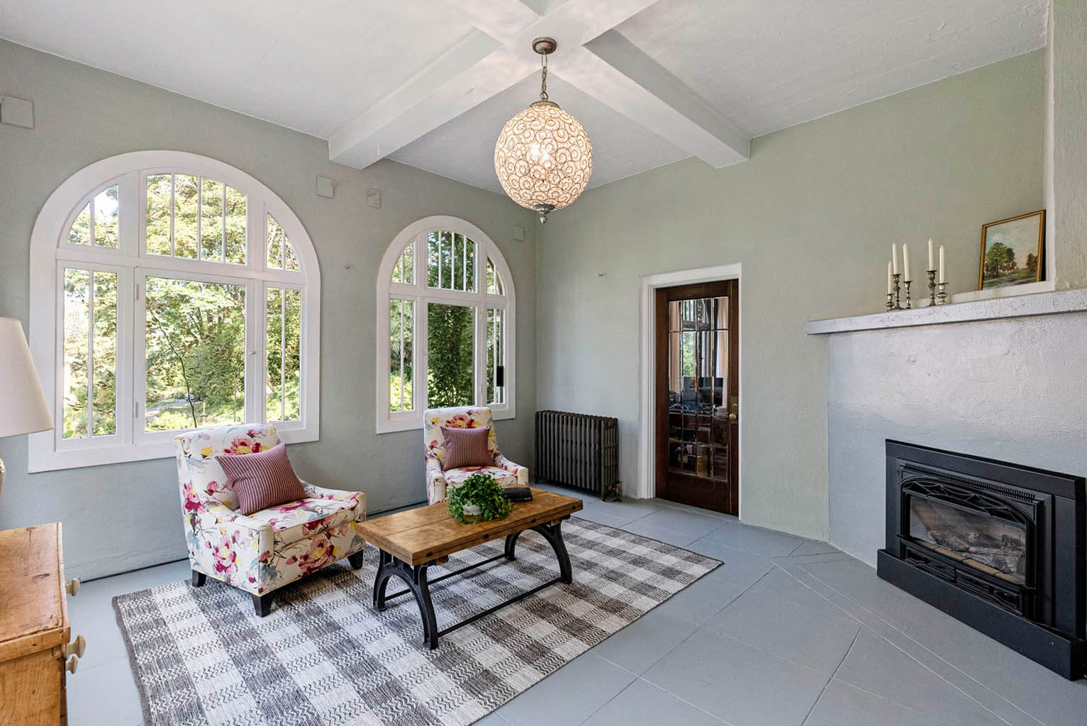 Enclosed porch with fireplace and Palladian windows is accessible from the library or the living room