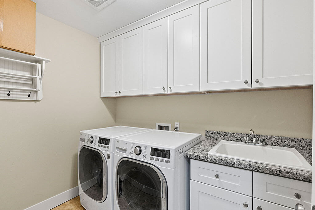 Upstairs laundry room with utility sink and storage (washer and dryer included)