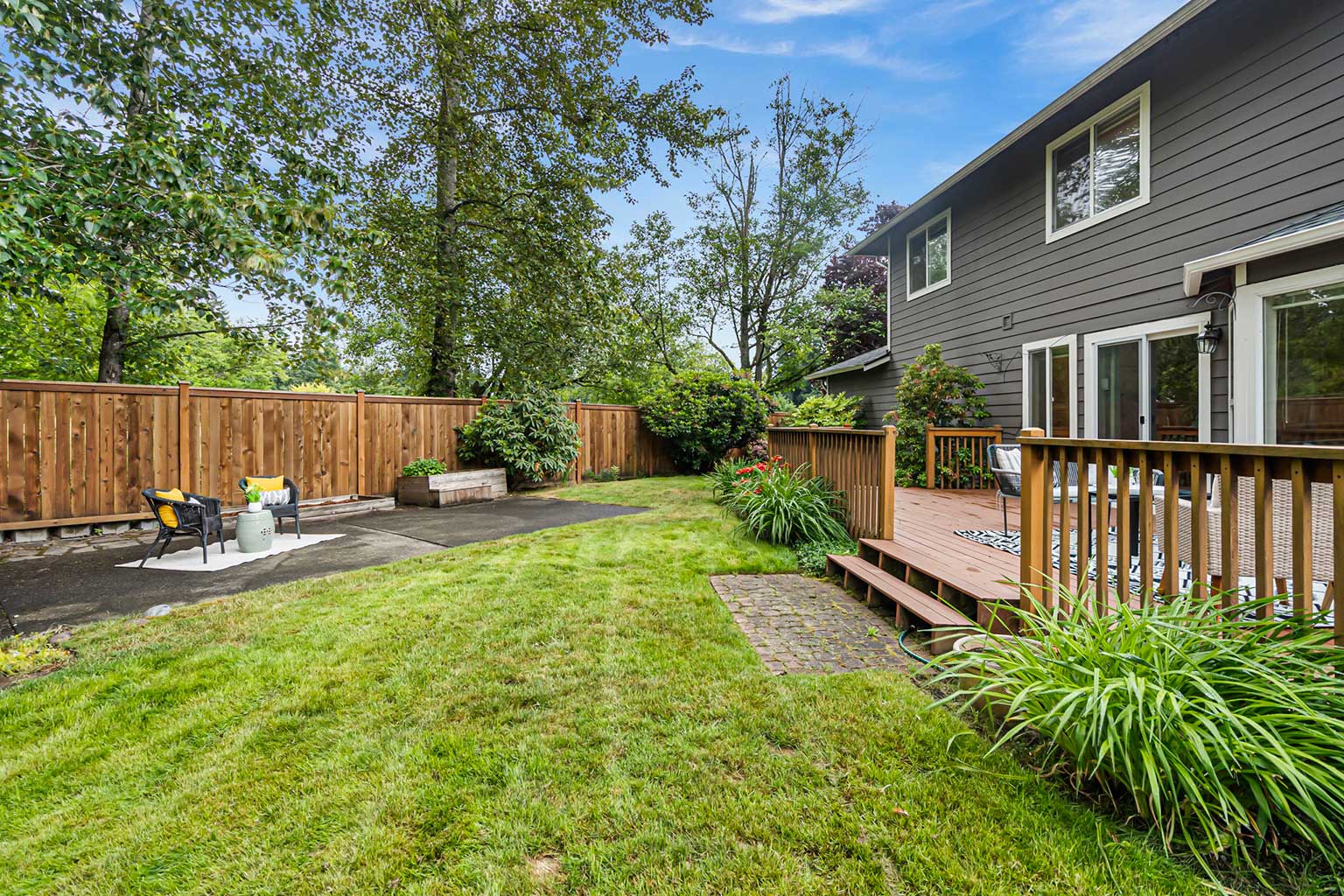 Fully fenced back yard with mature landscaping and sprinkler system