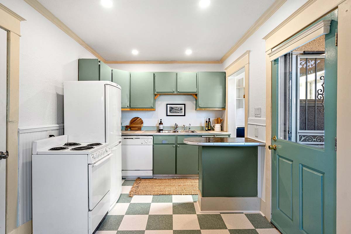 Kitchen features vintage tile flooring and side yard access